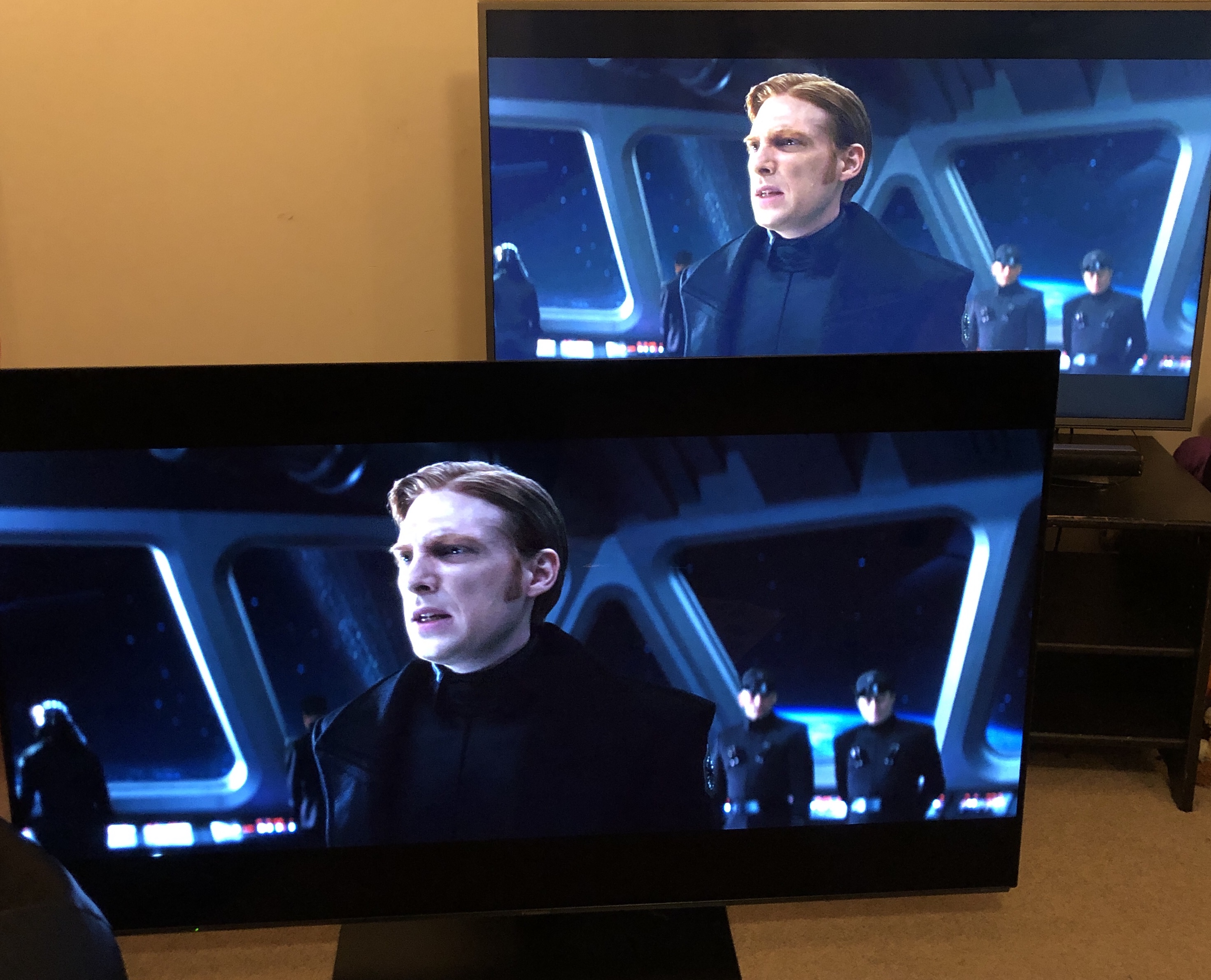 Two televisions showing the same frame from a Star Wars film, the one in the foreground has much higher contrast.